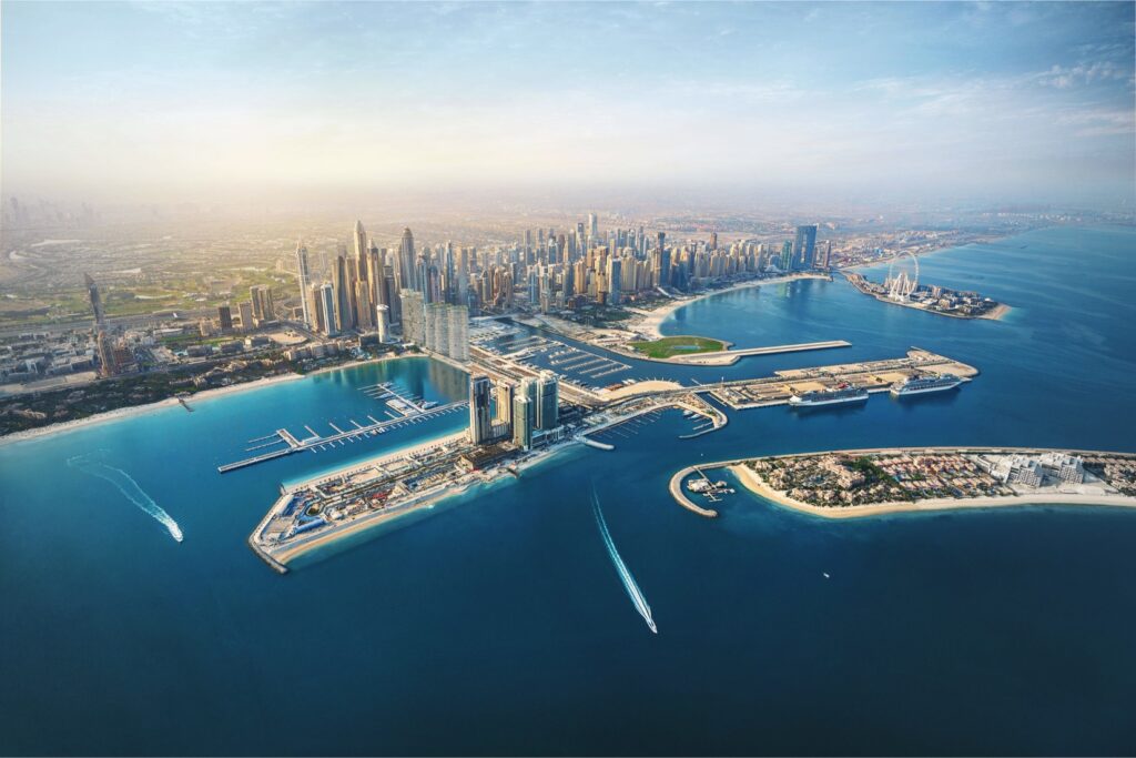 Aerial shot of DAMAC Bay 2 luxury residential towers in Dubai Harbour at sunset, showcasing marina, yachts, seafront promenade, and panoramic views of Palm Jumeirah and Dubai skyline